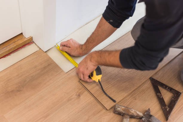 Male hand measuring distance between floor tiles and the wall